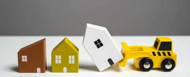 A bulldozer demolishes houses